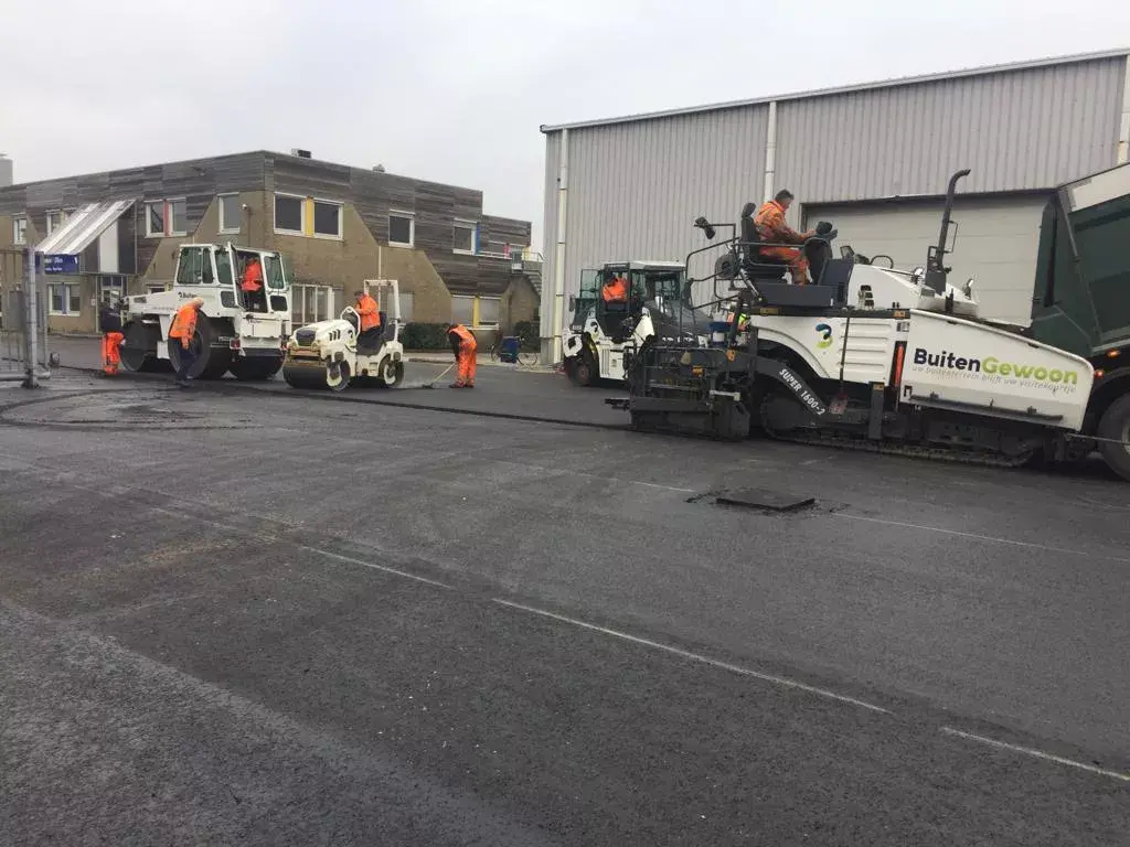 Workers-placing-new-coating-asphalt-road